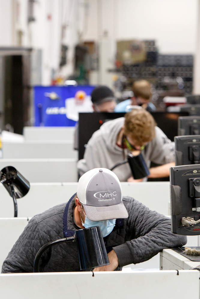 Staff photo by C.B. Schmelter / Colton Erwin, bottom, and three of his fellow students work in the Machine Tool Lab in the TCAT 2 Building on the campus of Chattanooga State Community College on Tuesday, May 19, 2020 in Chattanooga, Tenn. While most classes at the college have continued online, a few classes began instruction on campus on Monday.