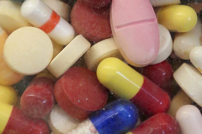 This July 6, 2017 file photo shows prescription drugs displayed in a glass flask (AP Photo/Rick Bowmer, File)