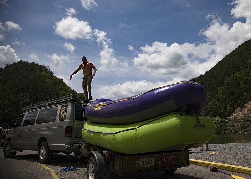 Staff photo by Troy Stolt / ACE Ocoee adventures river guide Ben Stephens unloads a raft from the roof of the company van before heading down the Ocoee river on Sunday, May 17, 2020 in Ocoee, Tenn. Commercial rafting trips were allowed to start back up last weekend, with guidelines set up in order to try to prevent the spread of Coronavirus.