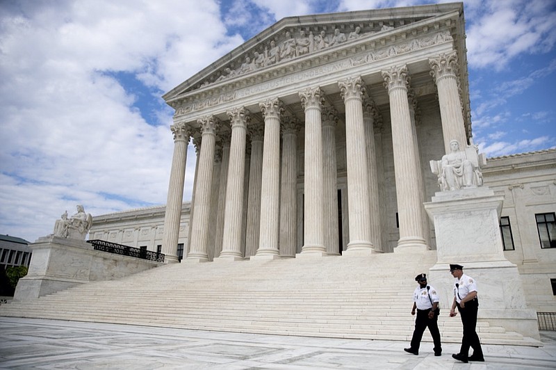 Security officers, one wearing a mask, walk in front of the Supreme Court, Thursday, May 14, 2020, in Washington. (AP Photo/Andrew Harnik)


