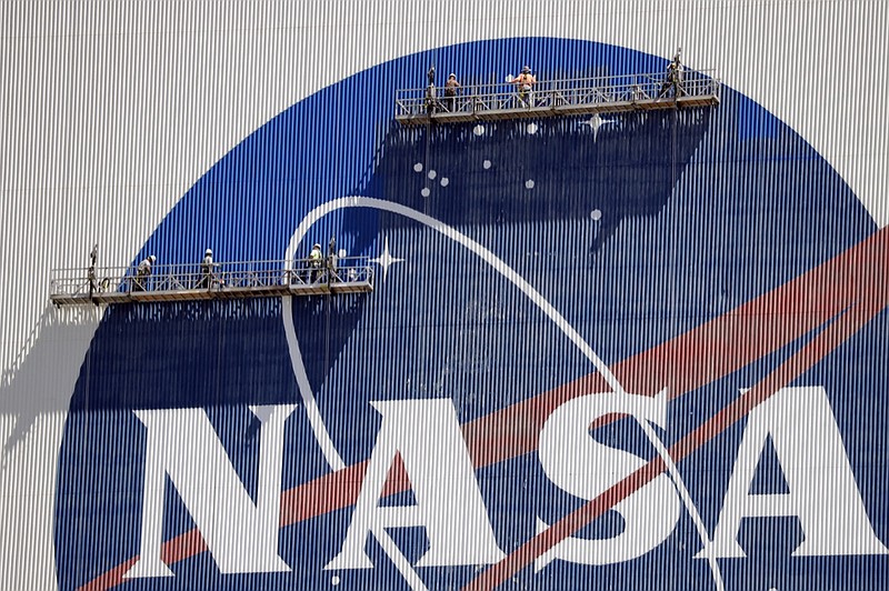 Workers near the top of the 526 ft. Vehicle Assembly Building at the Kennedy Space Center spruce up the NASA logo standing on scaffolds in Cape Canaveral, Fla., Wednesday, May 20, 2020. A SpaceX Falcon 9 rocket scheduled for May 27 will launch a Crew Dragon spacecraft on its first test flight with astronauts on-board to the International Space Station. (AP Photo/John Raoux)