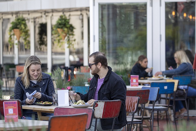 Emily Black, left, and Adam Weinstein have lunch on the outdoor patio of Mexicue restaurant, Wednesday, May 20, 2020, in Stamford, Conn. Restaurants can begin offering service in outdoor dining areas Wednesday as part of the first phase of Connecticut's statewide reopening, including in hard-hit Fairfield County on the New York state line. (AP Photo/Mary Altaffer)


