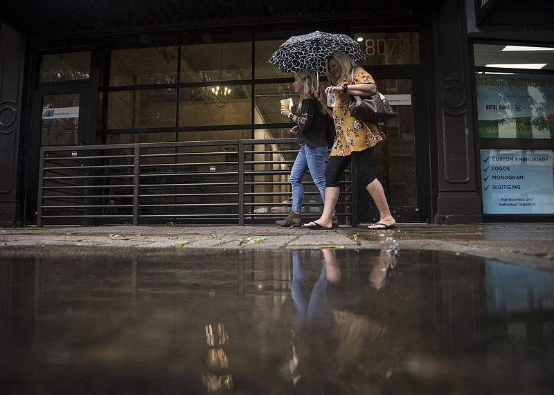 Staff photo by Troy Stolt / Heather McCallie and Rhonda Franssen walk down Market Street on Friday, May 22, 2020 in Chattanooga, Tenn. Rain has been forecasted in Chattanooga for the rest of Memorial Day Weekend.
