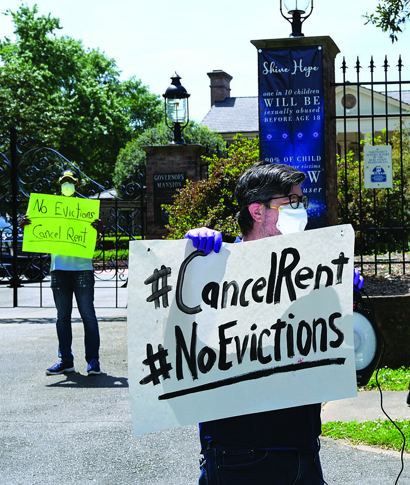 Greg Moore, center, carries a sign as he and other protesters stage a demonstration for protection from eviction due to COVID-19 outside the Governor's mansion in Little Rock, Arkansas, on Friday, May 1, 2020. (Arkansas Democrat-Gazette / Stephen Swofford)