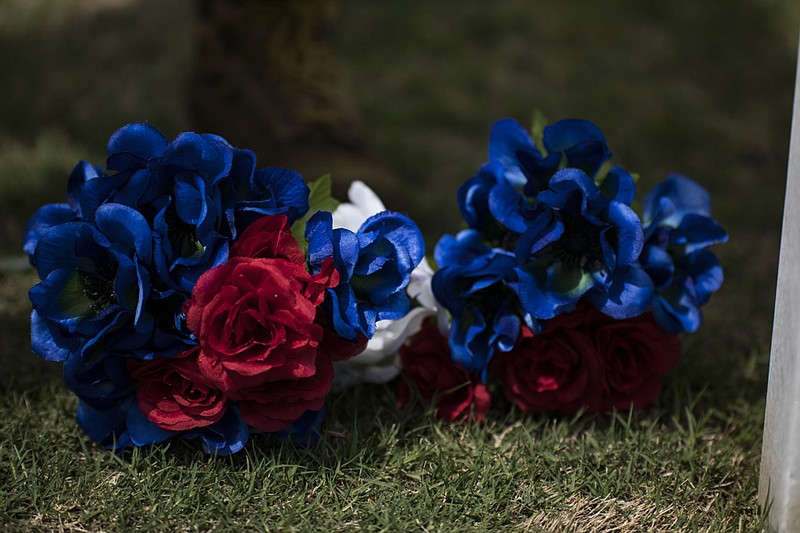 Staff photo by Troy Stolt / 72-year-old Vietnam war Veteran Henry Slayton places flowers at the grave of a deceased member of the American Veteran's Post 36 at the National Cemetery on Tuesday, May 19, 2020 in Chattanooga, Tenn. For the last seven years Slayton has honored his fellow veterans who have passed away before Veterans and Memorial Day, he plans to continue to do so for as long as he can.