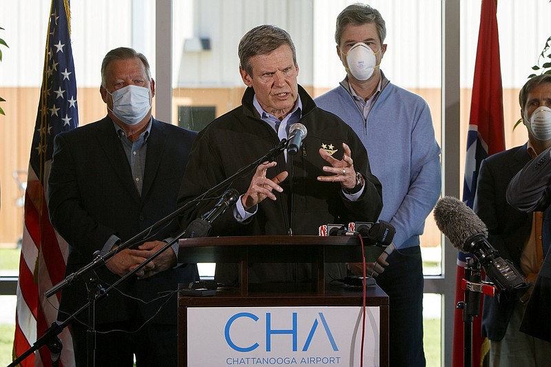 Staff photo by C.B. Schmelter / Gov. Bill Lee, flanked by Chattanooga Mayor Andy Berke, right,, and Hamilton County Mayor Jim Coppinger, left,, speaks during a press conference at Wilson Air Center on Tuesday, April 14, 2020 in Chattanooga, Tenn.