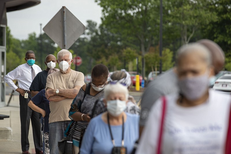 Alyssa Pointer, Atlanta Journal-Constitution via AP / Voters wearing face masks stood in line outside of the Gwinnett County Voter Registration and Elections Office in order to participate in early voting for Georgia's primary election in Lawrenceville, Ga., last Monday. Georgia's Election Day is June 9.