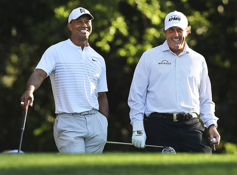 AP photo by Curtis Compton / Tiger Woods, left, and Phil Mickelson share a laugh on the 11th tee at Augusta National Golf Club on April 3, 2018, while playing a practice round for the Masters.