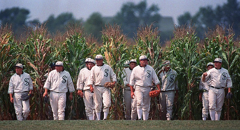 AP file photo by Charlie Neibergall / People portraying ghost baseball players, similar to characters in the 1989 film "Field of Dreams," emerge from the cornfield at the movie location site in Dyersville, Iowa.