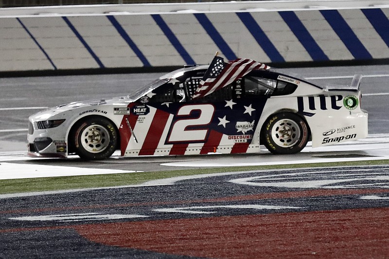 AP photo by Gerry Broome / Brad Keselowski holds an American flag after winning the NASCAR Cup Series' Coca-Cola 600 at Charlotte Motor Speedway, with the race in Concord, N.C., finishing early Monday morning after starting Sunday evening and experiencing a rain delay.