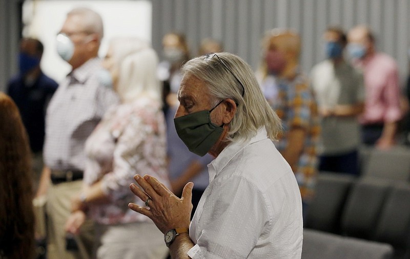 Pastor Denny Pagel prays during a service at Grace Bible Church on Sunday, May 24, 2020, in Tempe, Ariz. Parishioners practiced social distancing as the church held its first in-person service since March. (AP Photo/Ross D. Franklin)