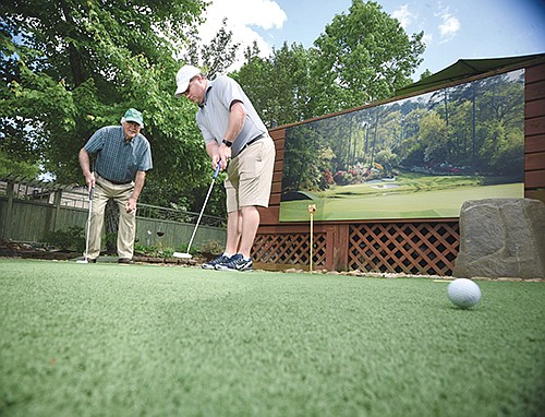 Staff photo by Tim Barber/ Nob North Golf Pro Eric Hester puts toward one of the holes at Buddy Nichols backyard golf course in East Ridge on Thursday, May 7, 2020. Nichols has a dream of getting local kids interested in the game by playing his artificial turf layout.