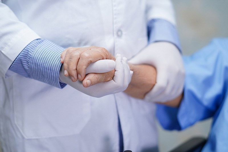 Doctor holding touching hands Asian senior or elderly old lady woman patient with love, care, helping, encourage and empathy at nursing hospital ward : healthy strong medical concept - stock photo hands coronavirus tile / Getty Images
