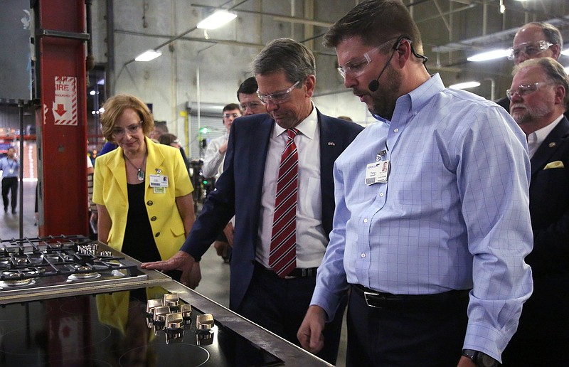 Staff file photo / Georgia Gov. Brian Kemp goes on a tour of GE Appliances' Roper plant led by Tony Gabbert, assembly operations director, last year in LaFayette.