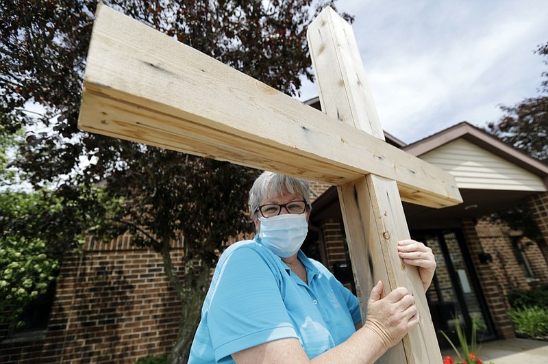 Associate Pastor Sharon Rogers poses for a portrait with a cross at Light of Christ Lutheran Church in Algonquin, Ill., Sunday, May 24, 2020. "The church is not a building, the church is people," said Rogers, explaining why parents had embraced the idea of an outdoor service for their children's upcoming confirmation ceremony. (AP Photo/Nam Y. Huh)


