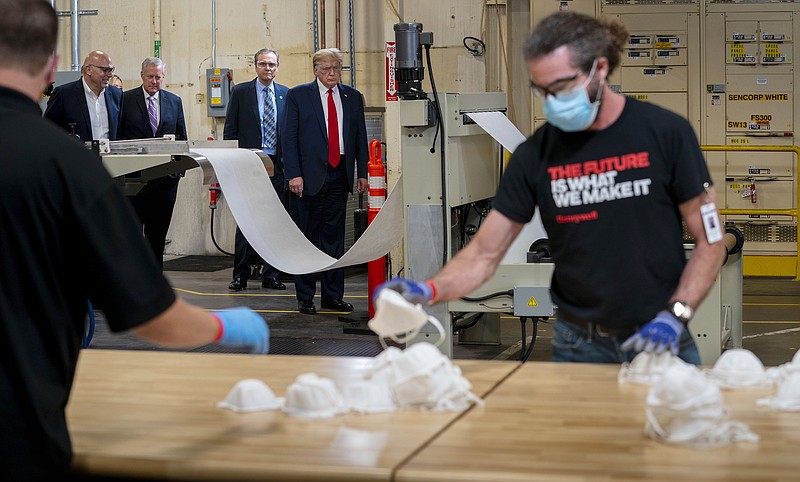 File photo by Doug Mills of The New York Times / President Donald Trump tours a Honeywell production facility making face masks in Phoenix on May 5. Now he is mocking people who wear masks.