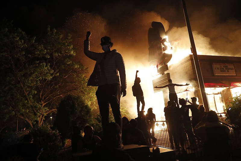 Protesters gather in front of a burning fast food restaurant Friday, May 29, 2020, in Minneapolis. Protests over the death of George Floyd, a black man who died in police custody Monday, broke out in Minneapolis for a third straight night. (AP Photo/John Minchillo)