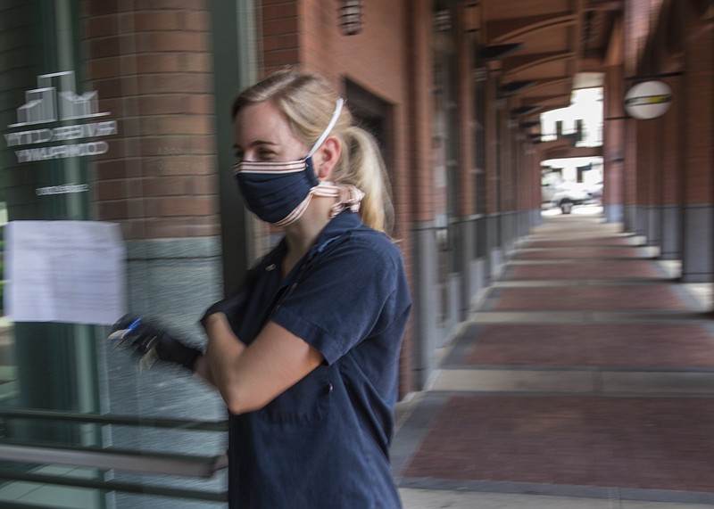 Staff photo by Troy Stolt / Ruth Ann Buckner opens a door during a shift at Community Pie on Thursday, May 28, 2020 in Chattanooga, Tenn. Studies have shown preventing the spread of COVID-19 is significantly more effective when masks are worn by everyone who goes out into public areas.