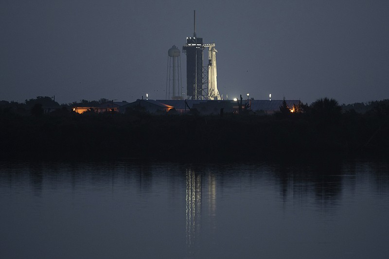 In this image provided by NASA, a SpaceX Falcon 9 rocket, with the company's Dragon crew capsule onboard, is illuminated on the launch pad at Launch Complex 39A as preparations continue for NASA's SpaceX Demo-2 mission, Saturday, May 30, 2020, at the Kennedy Space Center in Cape Canaveral, Fla. Despite more storms in the forecast, SpaceX pressed ahead Saturday in its historic attempt to launch astronauts for NASA, a first by a private company. (Joel Kowsky/NASA via AP)

