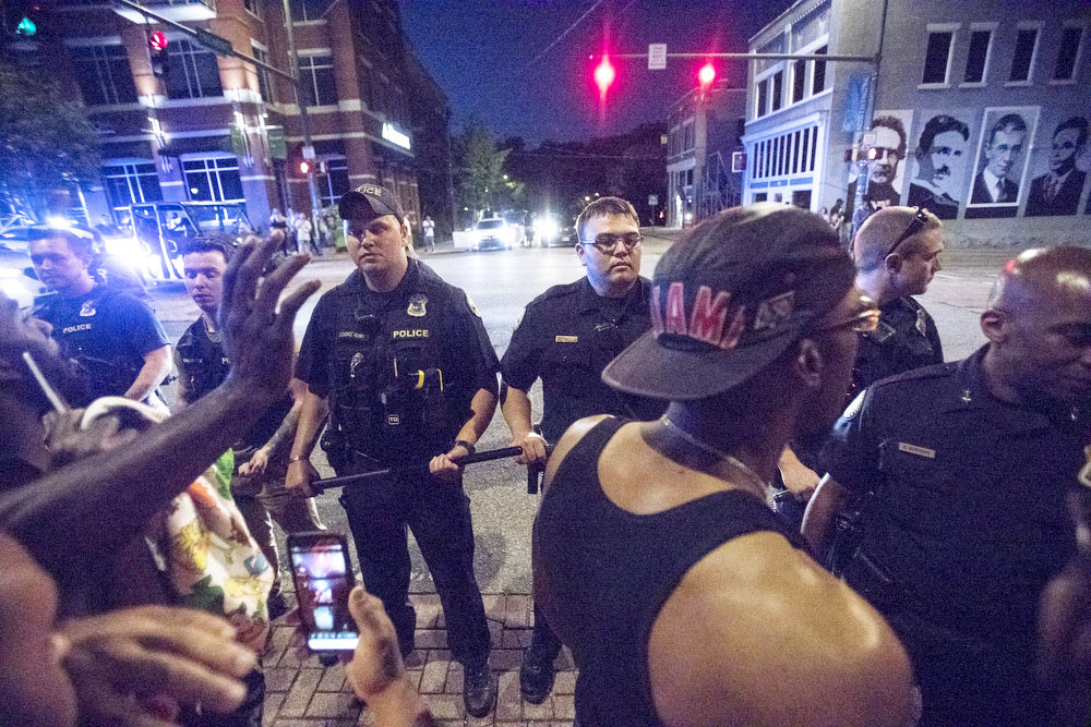 Staff photo by Troy Stolt / Police line up with batons to get control of a crowd at the intersection of Frazier Avenue and Tremont Street, Saturday night, during protests over the murder of George Floyd by Minneapolis police officers.