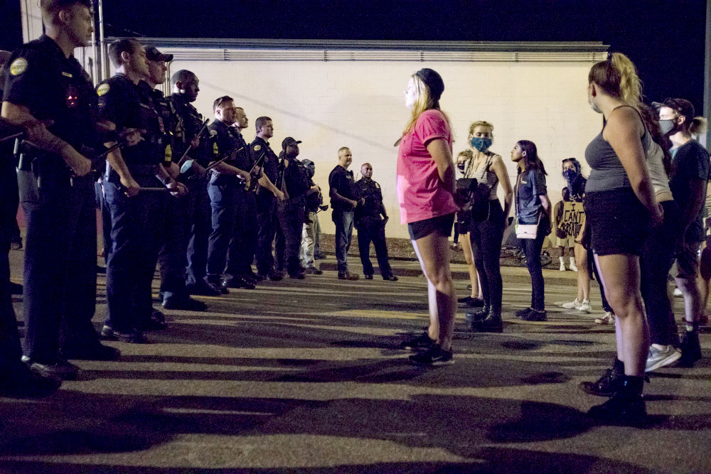 Staff photo by Troy Stolt / Protestors stand their ground, Saturday night, as Chattanooga police line up to clear Tremont Street during protests over the murder of George Floyd by Minneapolis police officers.
