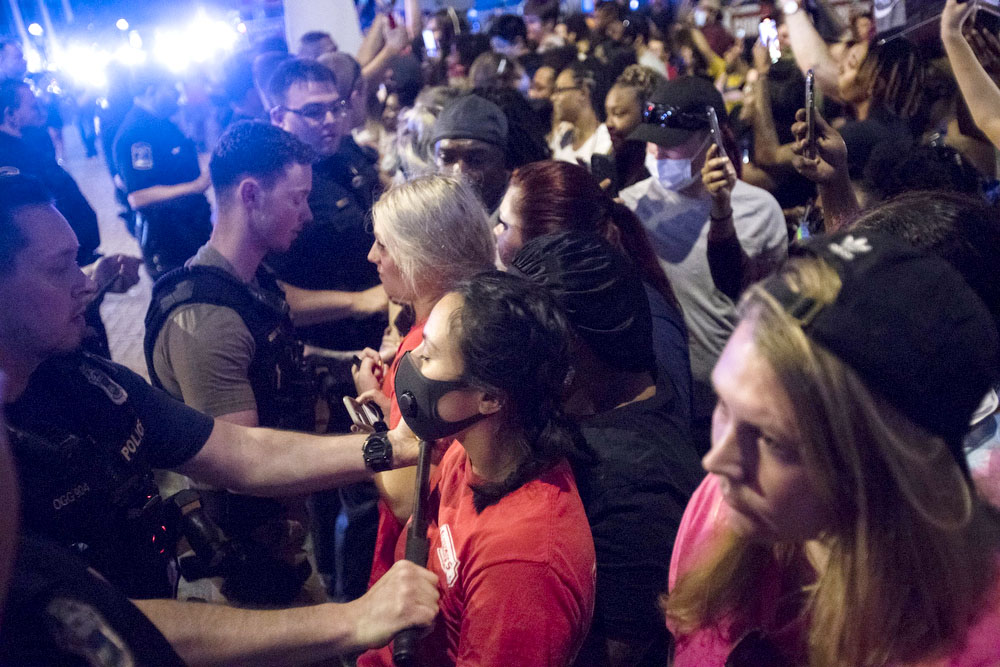 Staff photo by Troy Stolt / Police use night sticks, Saturday night, to push a crowd blocking traffic at the corner of Frazier Avenue and Tremont Street during a protest over the murder of George Floyd by Minneapolis police officers.