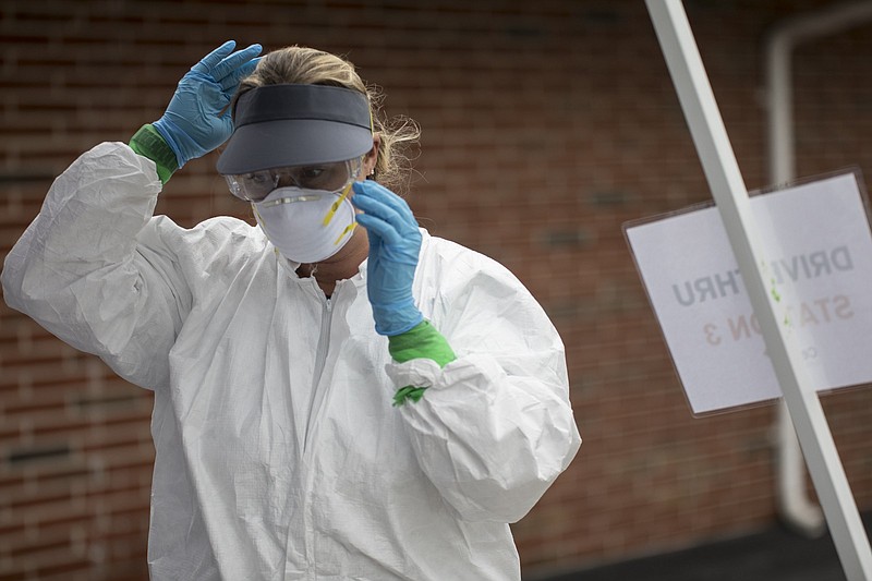 Staff photo by Troy Stolt / Clinician Amy Farlett Adjusts her PPE at a pop up test site being put on at the New Hope Baptist Church by Cempa Community care on Wednesday, May 27, 2020 in Chattanooga, Tenn.