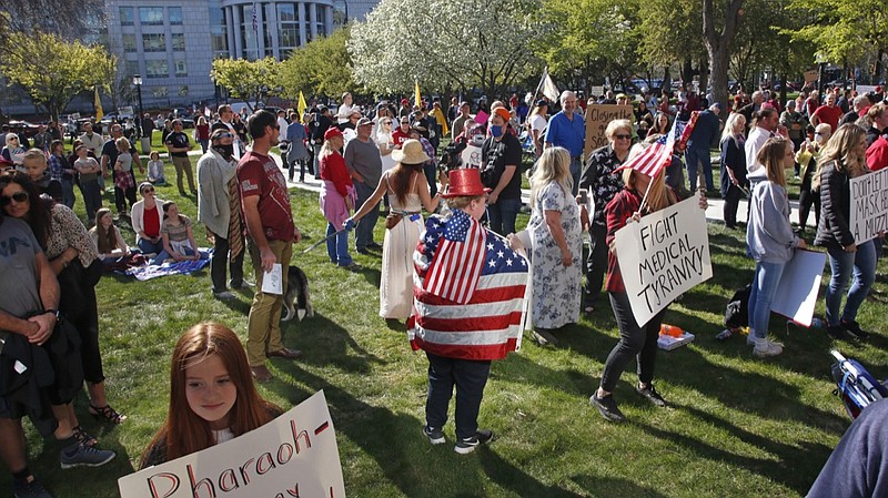 FILE - In this April 18, 2020 file photo people gather during the Utah Business Revival rally, calling for Utah's economy to be re-opened, in Salt Lake City. A Utah judge has blocked a concert protesting coronavirus restrictions, siding with county health officials who said the event expected to attract thousands of people could worsen the pandemic. Judge Dianna Gibson decided Friday, May 29, 2020, there was a real risk of spreading the virus among the audience and others they could bring it back to. (AP Photo/Rick Bowmer,File)