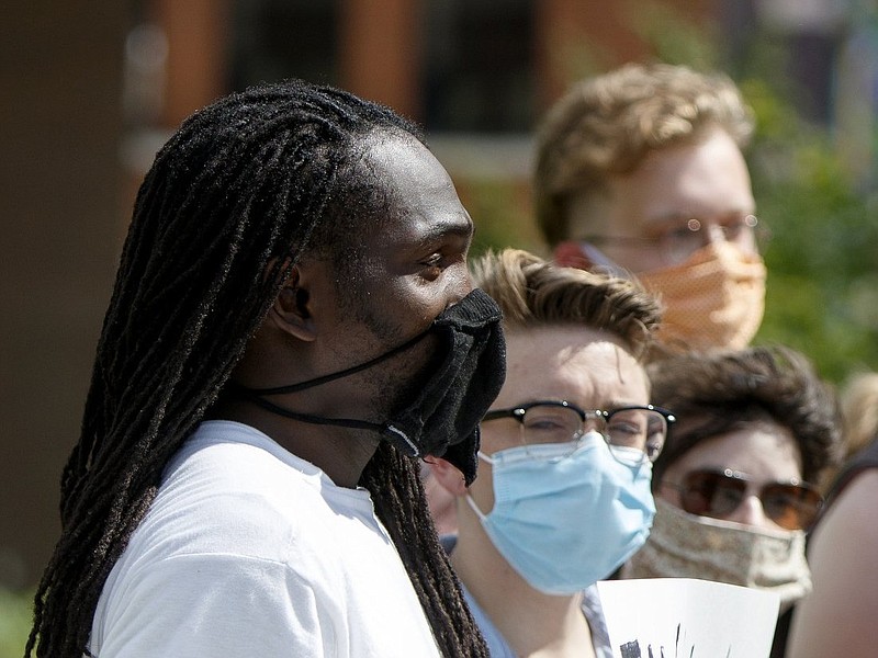 Staff photo by C.B. Schmelter / One of the cloth masks distributed by state health officials was worn by the protester at left during weekend demonstrations in Chattanooga against police brutality.