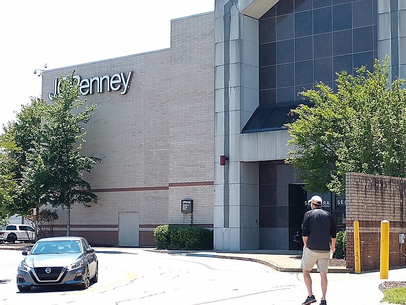 Staff photo by Mike Pare / A shopper at Hamilton Place mall heads to the parking lot and walks by the closed J.C. Penney store on Monday. The store is slated to reopen on Wednesday.