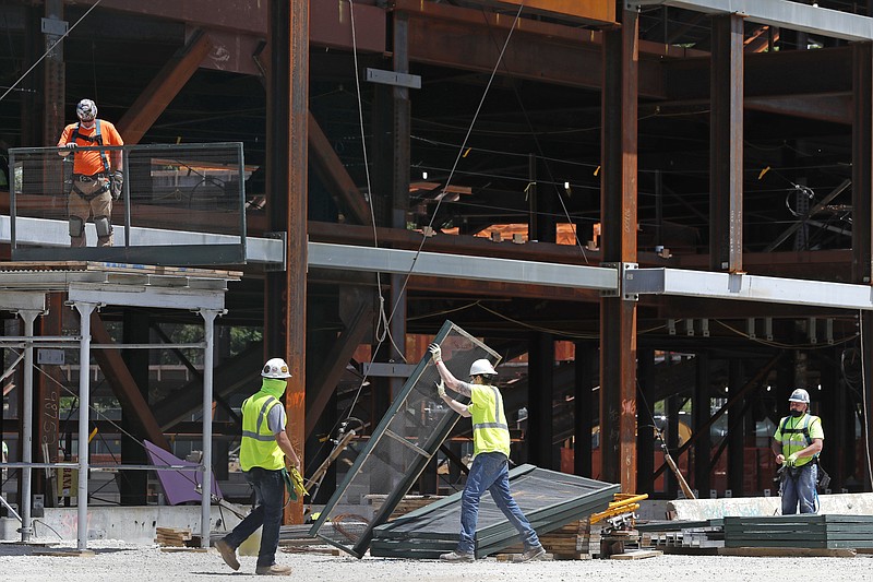 FILE - In this May 27, 2020 file photo, workers build a protective barrier as construction resumed on the New York Islanders' new arena,  in Elmont, N.Y.  U.S. construction spending fell 2.9% in April with all major sectors dropping as the shutdowns from the coronavirus had a big impact on the construction industry. The Commerce Department said that the April decline followed a basically flat reading in March (AP Photo/Kathy Willens, File)