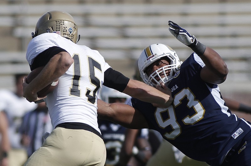Staff photo / UTC defensive lineman Keionta Davis, right, tackles Wofford quarterback Michael Weimer during the Mocs' 31-13 win over the visiting Terriers on Nov. 8, 2014, at Finley Stadium.