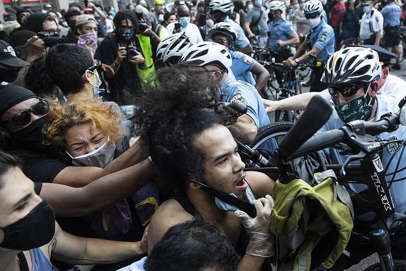 Police and protesters clash Saturday, May 30, 2020, in Philadelphia, during a demonstration over the death of George Floyd, a black man who was in police custody in Minneapolis. Floyd died after being restrained by Minneapolis police officers on Memorial Day, May 25. (AP Photo/Matt Rourke)

