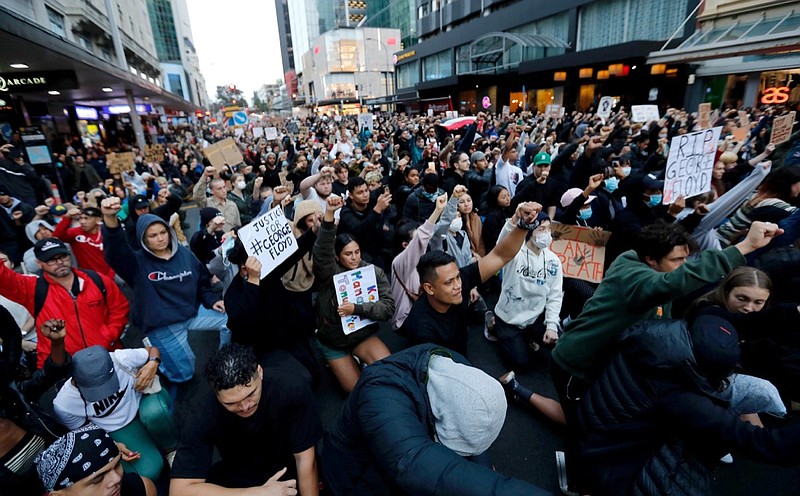 Demonstrators hold placards during a march in central Auckland, New Zealand, Monday, June 1. 2020, to protest the death of United States' George Floyd, a black man who died in police custody in Minneapolis on May 25. Floyd, who after a white police officer who is now charged with murder, Derek Chauvin, pressed his knee into Floyd's neck for several minutes even after he stopped moving and pleading for air. (Dean Purcell/New Zealand Herald via AP