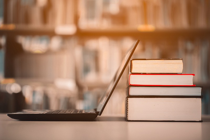 Bookshelves and laptops are placed on the library desk.E-learning class and e-book digital technology - (Getty/stock photo)