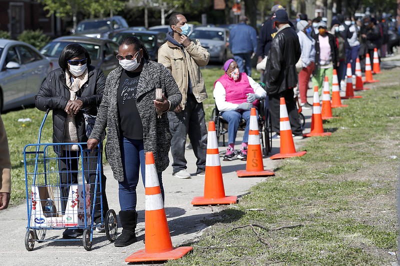 The Associated Press / Residents from all walks of life line up last month for a food giveaway sponsored by the Greater Chicago Food Depository.