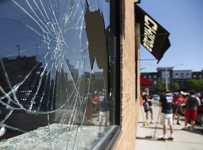 Photo by Rick West of the Daily Herald via The Associated Press / Volunteers congregate outside a Chico's store in downtown Naperville, Illinois, on Tuesday morning, June 2, 2020, following a night of looting and vandalism.