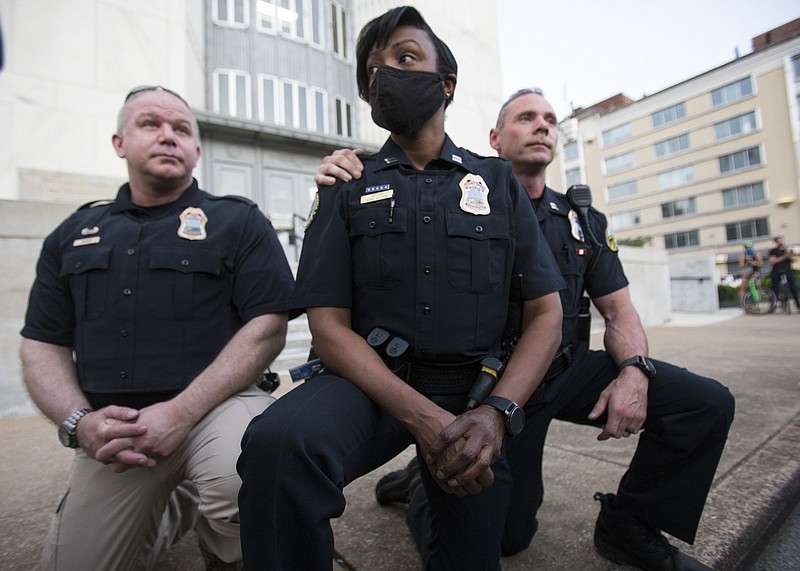 Staff photo by Troy Stolt / Three Chattanooga officers take a knee after a crowd of protesters asked them to do so in a show of solidarity as they demonstrated Monday evening to end police brutality in the aftermath of George Lloyd's death in Minnesota.