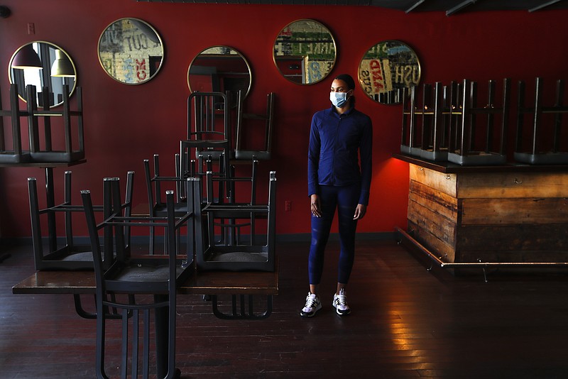 In this Thursday, May 21, 2020, image, Stephanie Byrd, co-owner of The Block, poses for a photo with chairs on the tables while the restaurant is closed due to the coronavirus in Detroit. She's worried other black-owned businesses will struggle to withstand another wave of economic uncertainty during the pandemic, following decades of inequity that made it hard for many to flourish in the first place. (AP Photo/Paul Sancya)


