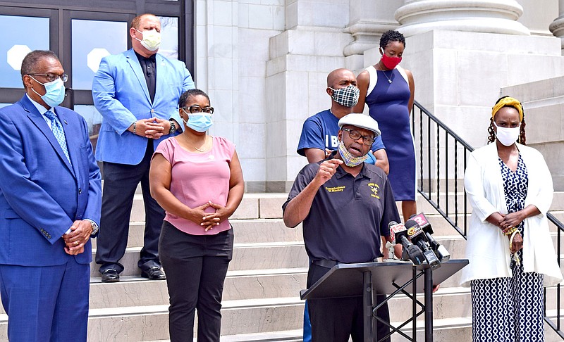 Staff Photo by Robin Rudd / Hamilton County Commissioner Warren Mackey, at podium, speaks at a news conference, joined by other black elected officials, on the steps of the Hamilton County Courthouse about recent concerns from the black community.