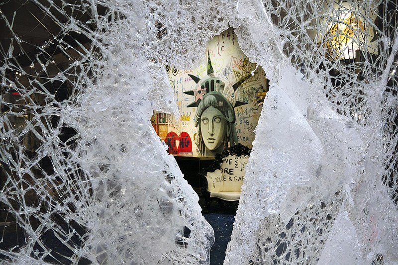 The Associated Press / A Statue of Liberty painting is seen through a smashed Dolce and Gabbana store window earlier this week in the SoHo neighborhood of New York after looters broke into the store in reaction to George Floyd's death while in police custody on May 25 in Minneapolis.