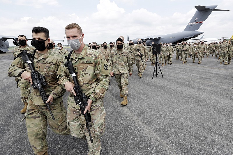 Tennessee National Guard troops prepare to board a plane in Smyrna, Tenn., to go to Washington, Thursday, June 4, 2020. They are being sent to help with security during protests over the death of George Floyd, a black man who died while being restrained by police in Minneapolis. (AP Photo/Mark Humphrey)

