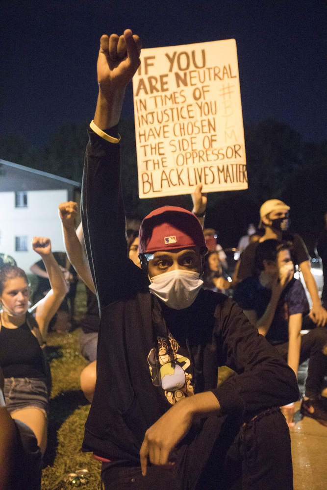 Staff photo by Troy Stolt / A protester raises his fist while kneeling in College Hill Courts during a peaceful demonstration on the sixth day of protests over the death of George Floyd on Thursday, June 4, 2020 in Chattanooga, Tenn.
