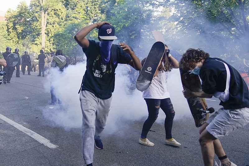 Demonstrators, who had gathered to protest the death of George Floyd, begin to run from tear gas used by police to clear the street near the White House in Washington, Monday, June 1, 2020. Floyd died after being restrained by Minneapolis police officers. (AP Photo/Evan Vucci)