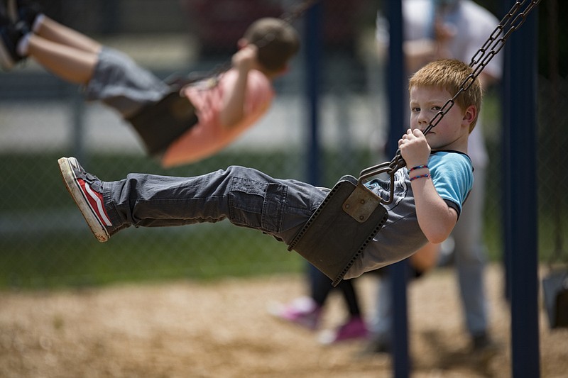 Staff photo by Troy Stolt / Maddox Caillat, 7 plays on the swings during recess time during summer child care at East Ridge Elementary on Friday, June 5, 2020 in East Ridge, Tenn.