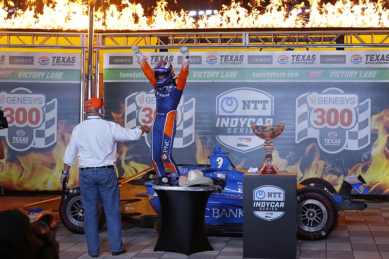 AP photo by Tony Gutierrez / Car owner Chip Ganassi, left, looks on as veteran driver Scott Dixon celebrates in victory lane Saturday night at Texas Motor Speedway after winning the IndyCar season opener in Fort Worth. The open-wheel series finally got going nearly three months after its scheduled opener in Florida was called off due to the coronavirus outbreak.