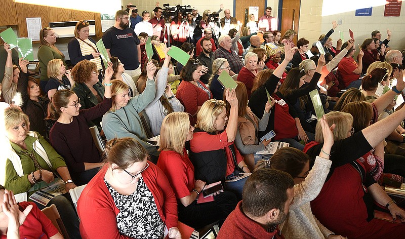 Staff file photo by Robin Rudd/ Attendees at a town hall on Nov. 17, 2019, hold up green cards to answer in the affirmative to a question raised at the town hall, organized by a local teacher advocacy group. Hamilton County United held a teacher town hall at the Brainerd Youth and Family Development Center discussing funding for public education and increasing teacher pay.