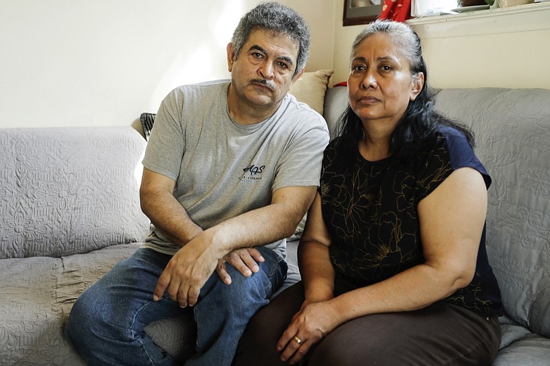 In this Thursday, June 4, 2020, photo, Francisco Flores, left, poses for a portrait with his wife Livia Herrera in New York. When his brother Crescencio Flores died of coronavirus in New York, his parents back in Mexico asked for one thing: that their son be sent home for burial. So far, his efforts have been in vain. "I am trying to do this because my parents, 85 and 87 years old, live there," Francisco Flores said. "They are rooted in their customs. They want a Christian burial for the remains of their son." (AP Photo/Frank Franklin II)