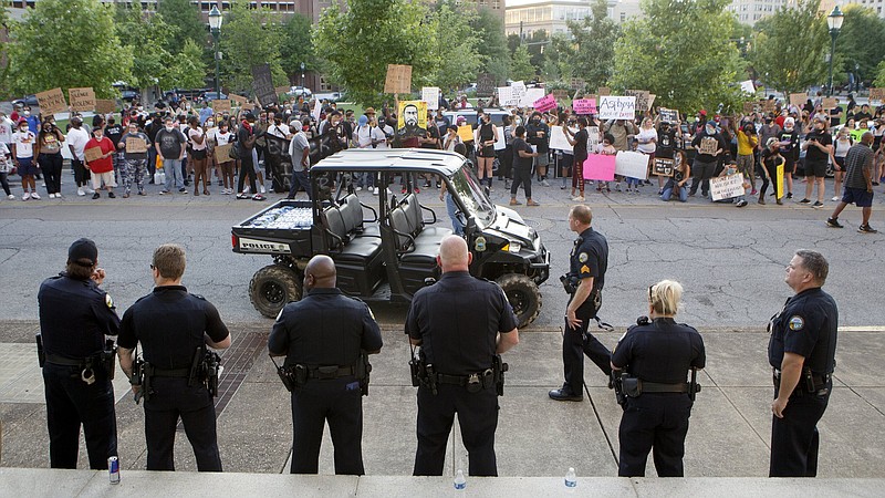 Staff photo by C.B. Schmelter / Protestors and police stand on opposite sides of Georgia Avenue near Miller Park on Monday, June 1, 2020 in Chattanooga, Tenn. The people were protesting the death of George Floyd. Floyd, 46, died after being handcuffed and pinned for several minutes beneath Minneapolis police Officer Derek Chauvin's knee. Protests entered their third night in Chattanooga.