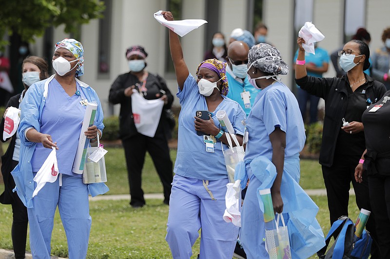 FILE - In this May 15, 2020, file photo, healthcare workers at New Orleans East Hospital wave handkerchiefs and dance to a jazz serenade, as a tribute for their care for COVID-19 patients, by the New Orleans Jazz Orchestra, outside the hospital in New Orleans. An act of generosity or self-sacrifice. A whimsical gesture to distract neighbors from anxiety or cabin fever. A helping hand to a person thrown out of a job, support for a patient struggling with COVID-19, solidarity with the medical professional toiling day and night to save them. Nearly three months later, there's been no end to the tales of good deeds we've found. (AP Photo/Gerald Herbert, File)


